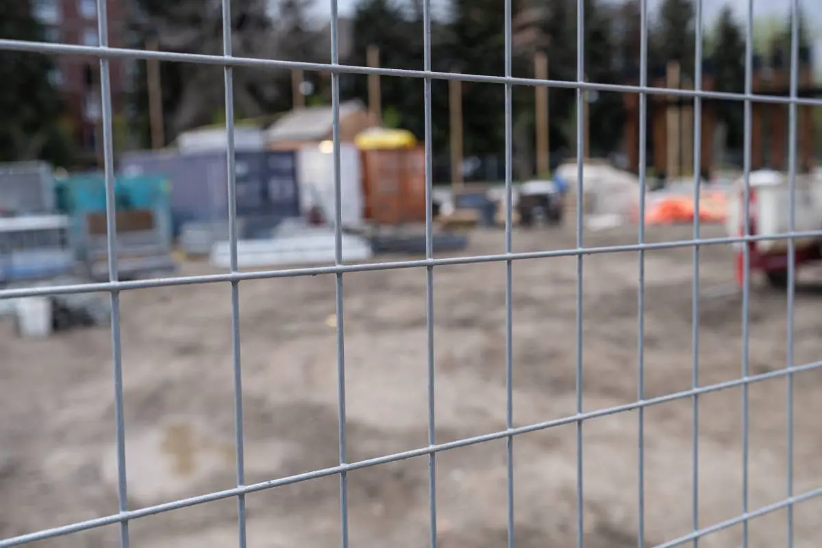 Safe & Secure Construction site behind chain link wire fence in Calgary